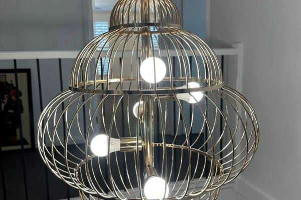 Ornate cage-style pendant light hanging in a stairwell – Marmont Electrical