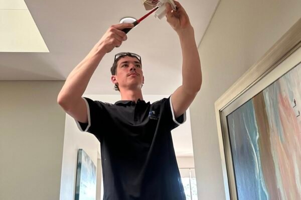 Electrician installing a ceiling light fitting overhead – Marmont Electrical